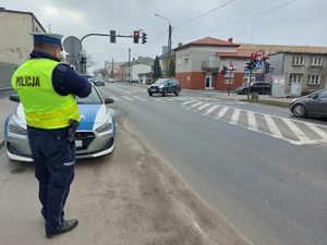 Policjant obserwuje oznakowane przejście dla pieszych.