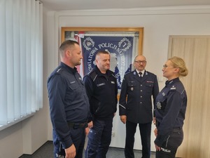 Czworo umundurowanych policjantów stoi.