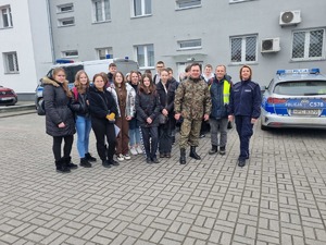 Zdjęcie grupowe, młodzież stoi, umundurowany policjant stoi.