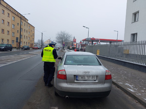 Policjanci Ruchu Drogowego kontrolują kierowcę samochódu osobowego.