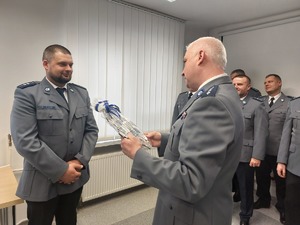 Daniel Piotrowski policjant gratuluje policjantom emerytom.