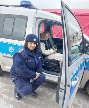 Policjantka pokazuje dziewczynce radiowóz.