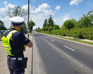 Policjant z ruchu drogowego mierzy prędkość