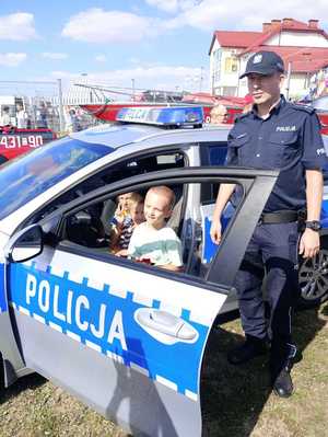 Policjant pokazuje dzieciom radiowóz