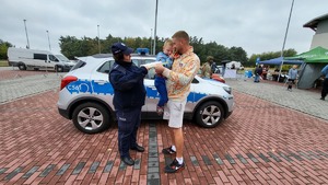 Policjantka rozdaje dzieciom odblaski