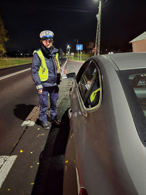 Policjantka daje kierującemu broszurę.