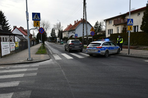 Policjanci pracują na miejscu wypadku drogowego.