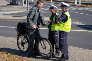Policjanci ruchu drogowego kontrolują rowerzystę.