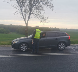 Policjant ruchu drogowego sprawdza trzeźwość kierowcy.