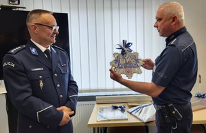 Policjant wręcza upominek dla emeryta