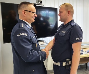 Policjant ruchu drogowego gratuluje przejścia Naczelnikowi na emeryturę