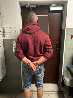 zatrzymany kierowca stoi z kajdankami na przegubach